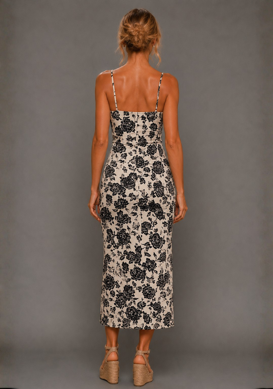 Back image of a model wearing the VSPR Cora Square Neck Champagne Midaxi Dress, showing the sleek back detailing and elongated midaxi hemline with a subtle split, standing against a grey studio backdrop
