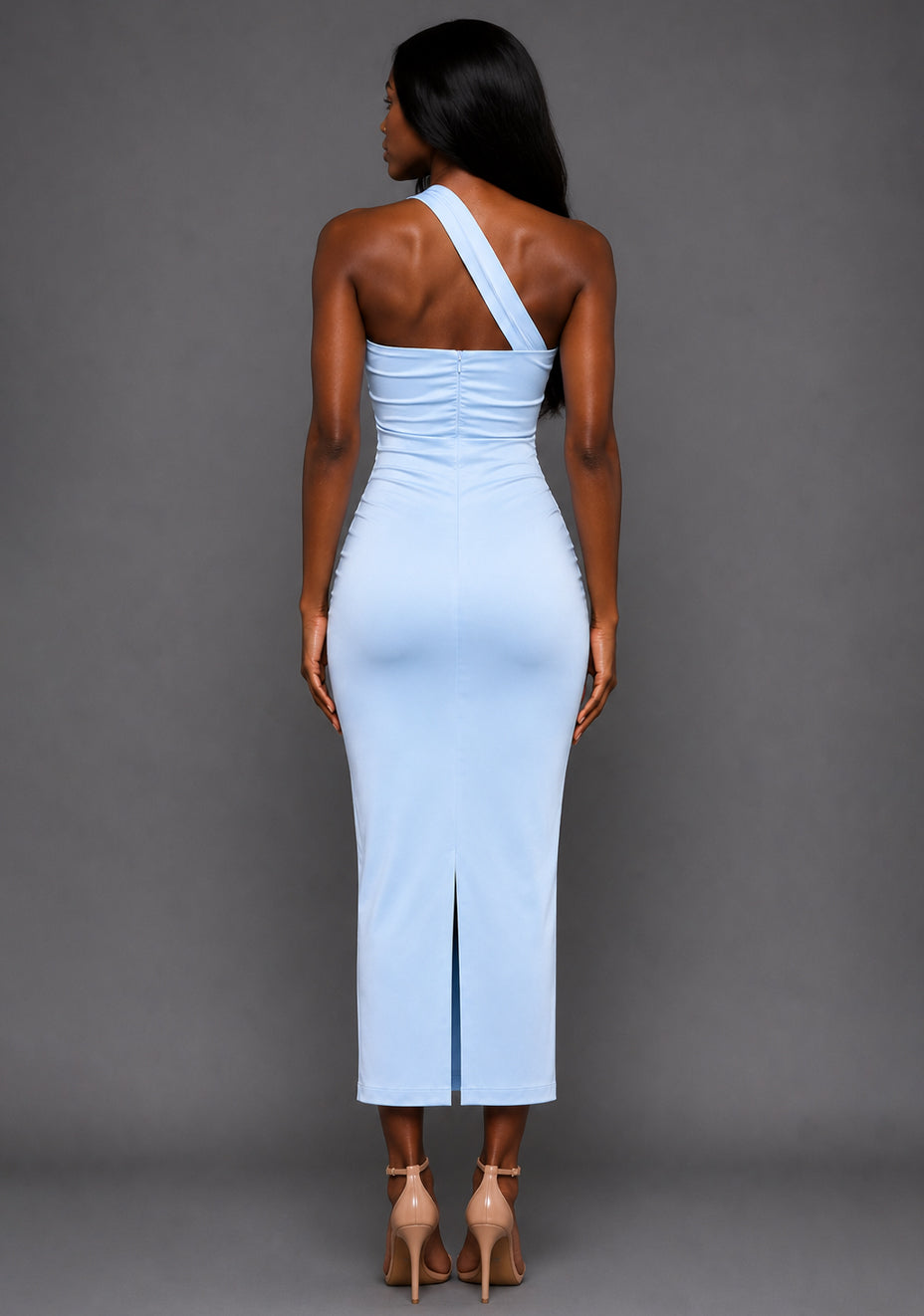 Back image of a model wearing the VSPR Tierney One Shoulder Cut Out Blue Midaxi Dress, featuring a clean fitted silhouette and luxurious satin fabric drape, standing against a grey studio backdrop.