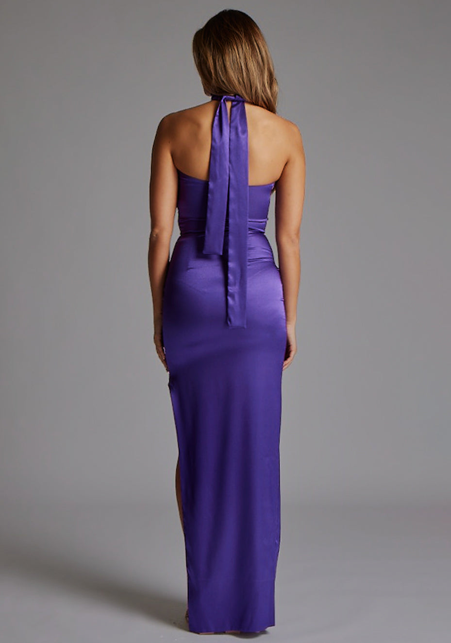 Back image of a model wearing the Vesper Bessie Satin Scarf Detail Maxi Dress in Purple, featuring a clean, minimalist back design and flowing satin fabric
