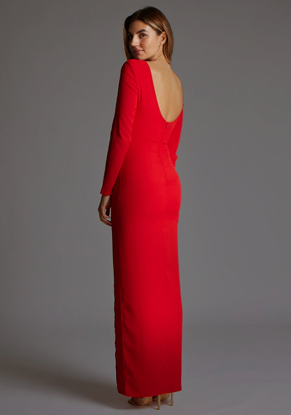Side back image of a model wearing the Vesper Mandy High Neck Long Sleeve Maxi Dress in Red, revealing the subtle scoop back detail and sculpted waistline.