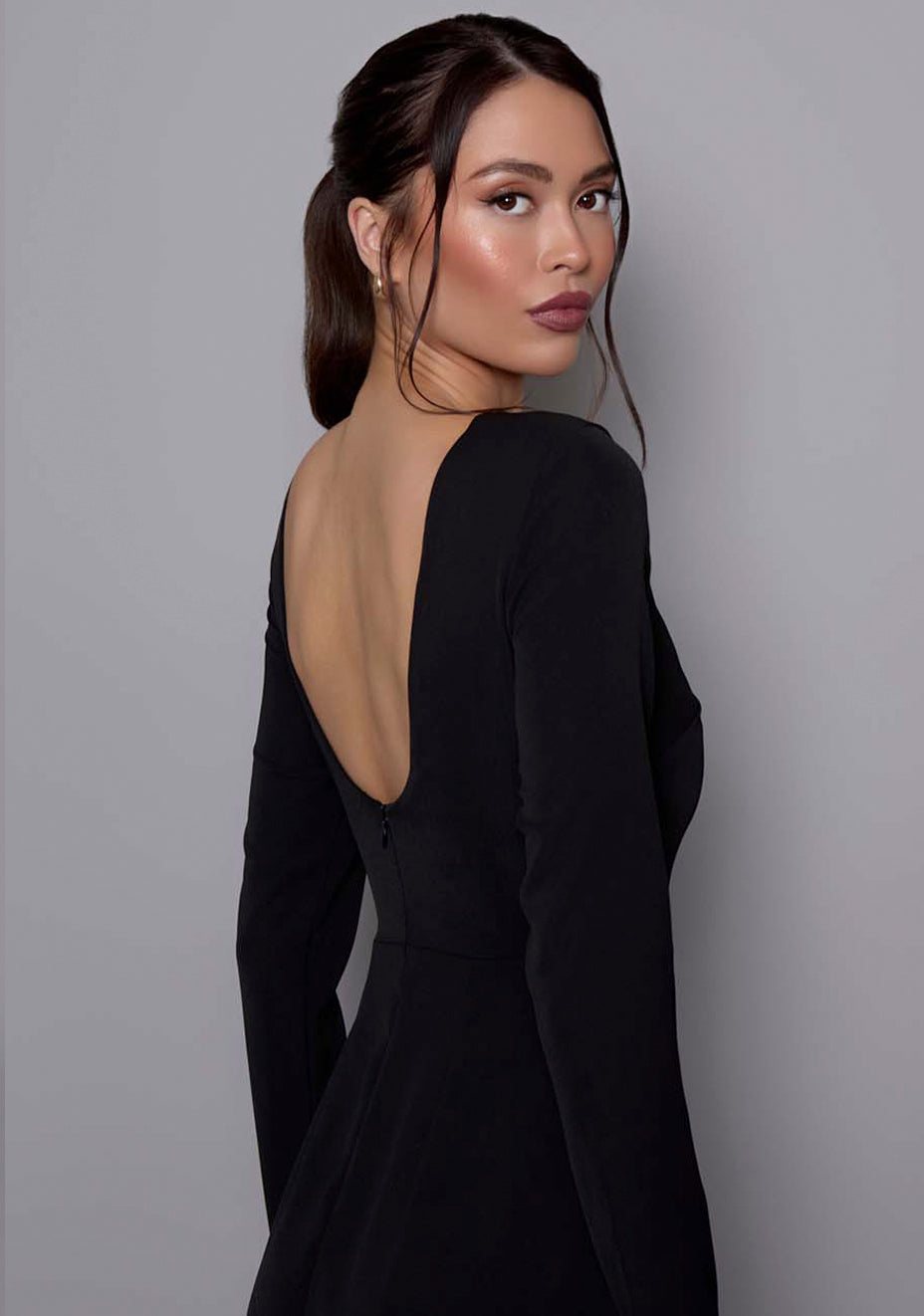 Close-up side-back image of the VSPR Mandy Dress highlighting the smooth fabric texture, round neckline, and front skirt split, with a focus on the dress's elegant design.