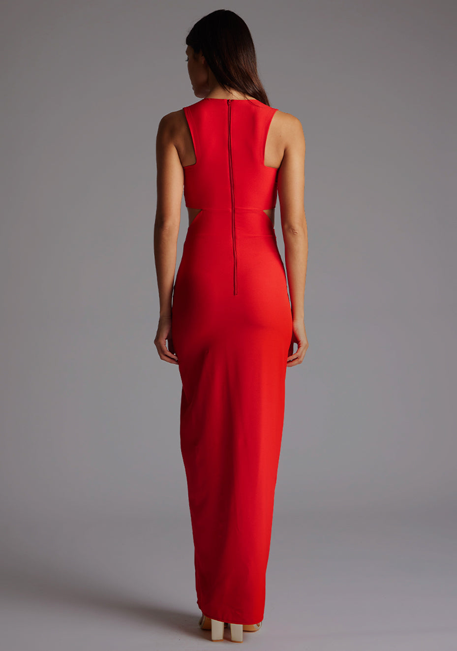 Back image of a model wearing the VSPR Paige Cut Out Maxi Dress in Red, showcasing the clean back design and floor-length skirt.