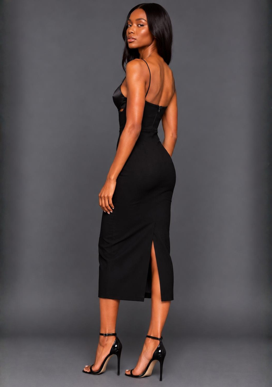 Side-back image of a model wearing the VSPR Angelina Strappy Cut Out Black Midaxi Dress, highlighting the fitted skirt, smooth fabric, and rear split hem.
