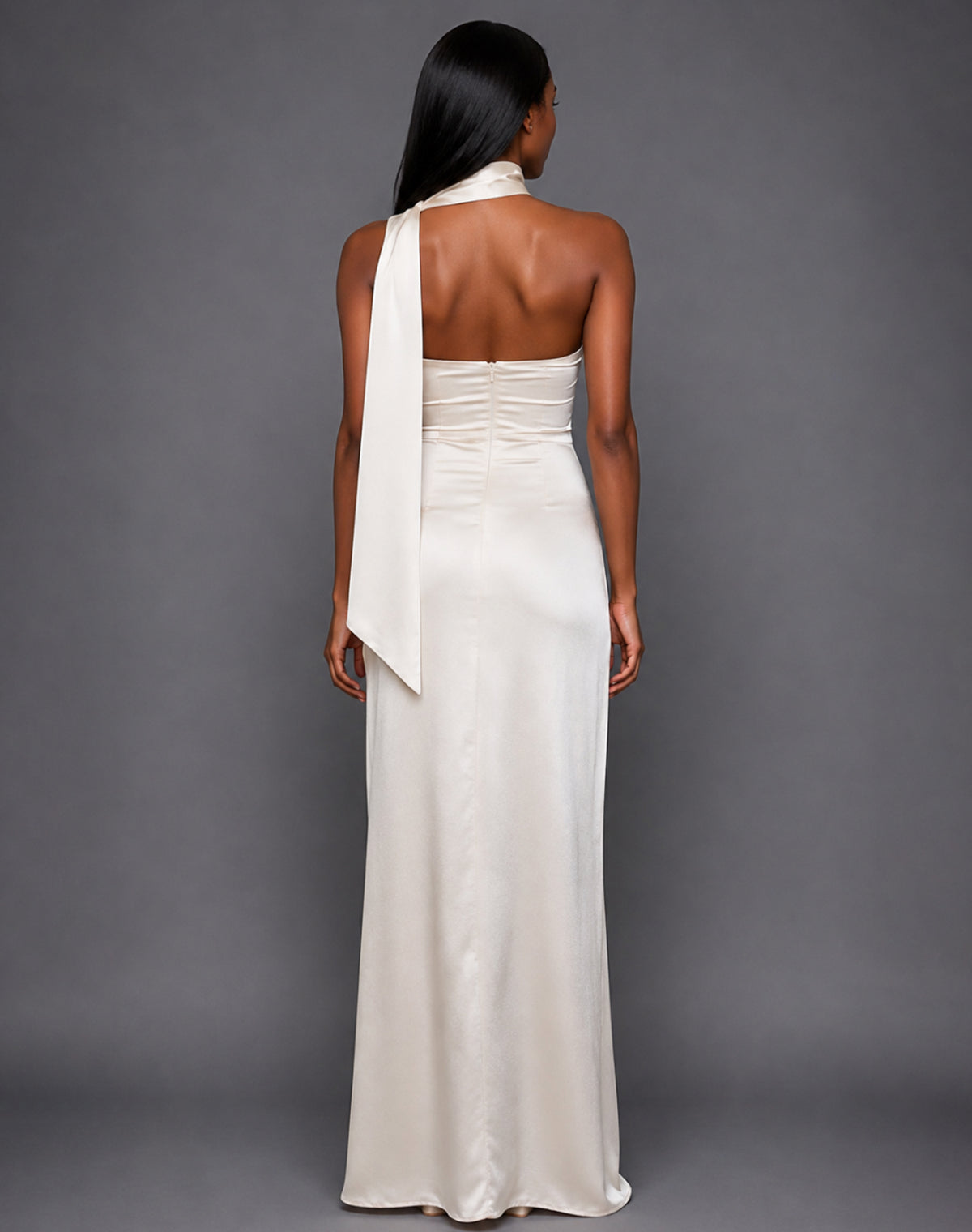 Back image of a model wearing the VSPR Cordula Cream Maxi Dress, showcasing the smooth satin finish, graceful drape, and elongated maxi silhouette against a grey studio backdrop