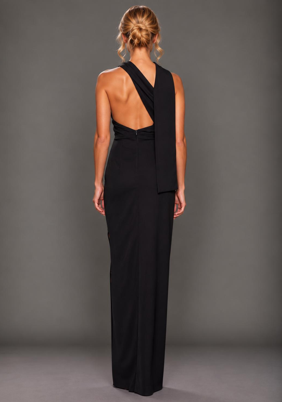 Back image of a model wearing the VSPR Kendall Strappy Sweetheart Navy Midaxi Dress, showcasing the rear neckline, delicate straps, and clean fitted design against a grey studio backdrop.