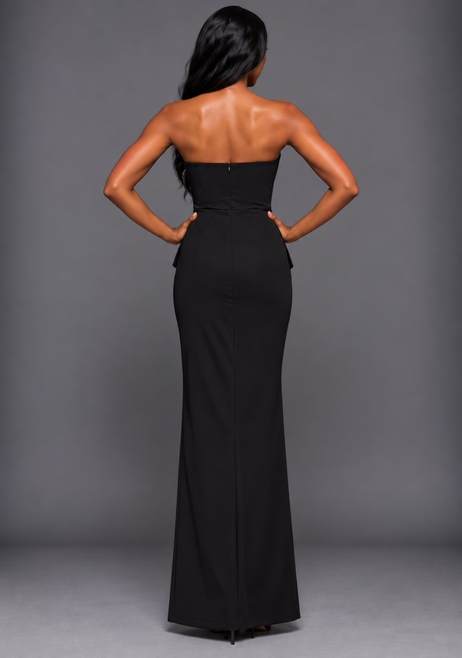 Back image of a model wearing the VSPR Isabel Bandeau Ruched Waist Detail Black Maxi Dress, showcasing the strapless back neckline and sleek, fitted floor-length silhouette.