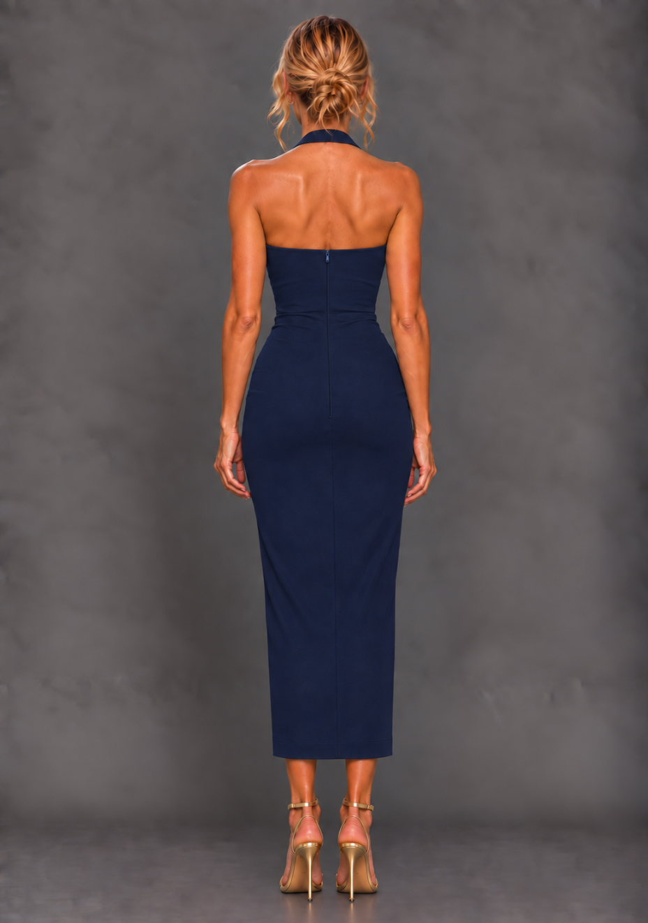 Back image of a model wearing the VSPR Maria Halterneck Thigh Split Navy Midaxi Dress, showcasing the back button fastening and centre-back zip against a grey studio backdrop.