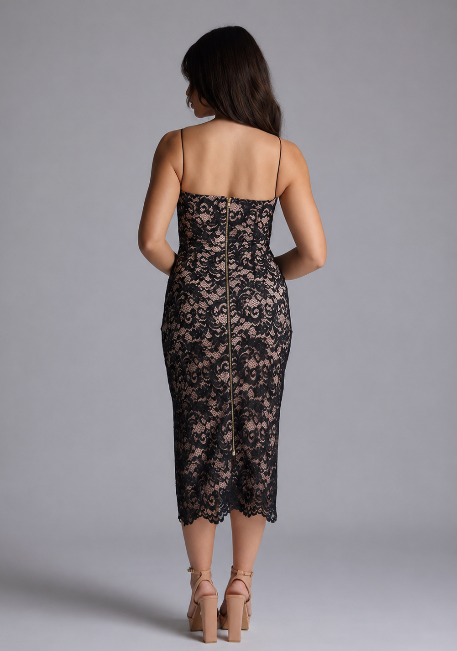 Woman wearing the Vesper Petite Arden black lace bodycon midaxi dress against a grey background, back view