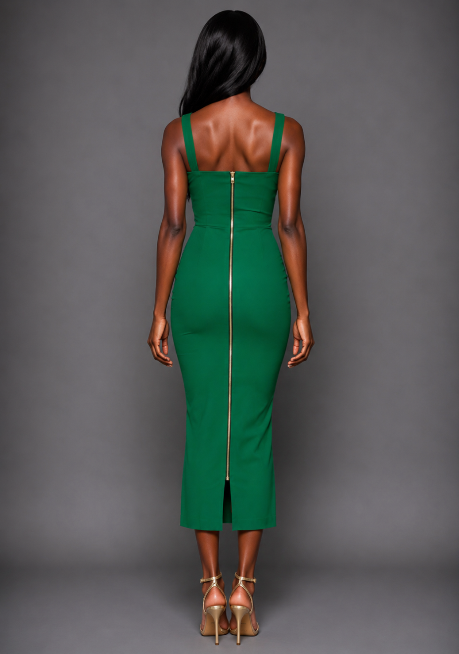 Back image of a model wearing the VSPR Pallas emerald green Midaxi Dress with a gold centre-back zip and sleek body-skimming silhouette against a grey studio backdrop