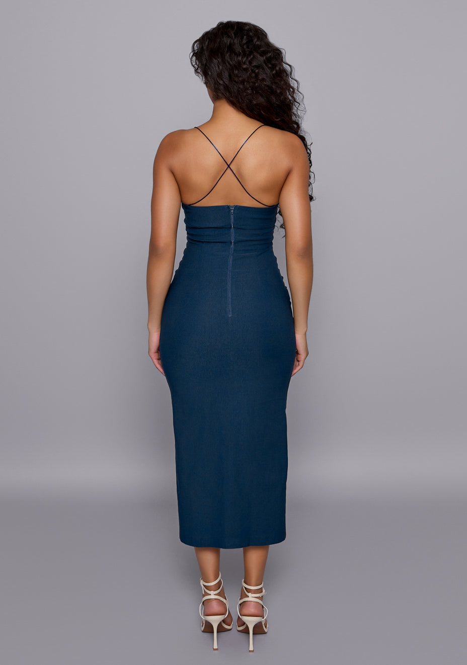 Back view of the VSPR Beryl Navy Dress featuring crisscross thin straps, clean back‑zip closure, and sleek fitted midaxi length that accentuates an elegant posture.