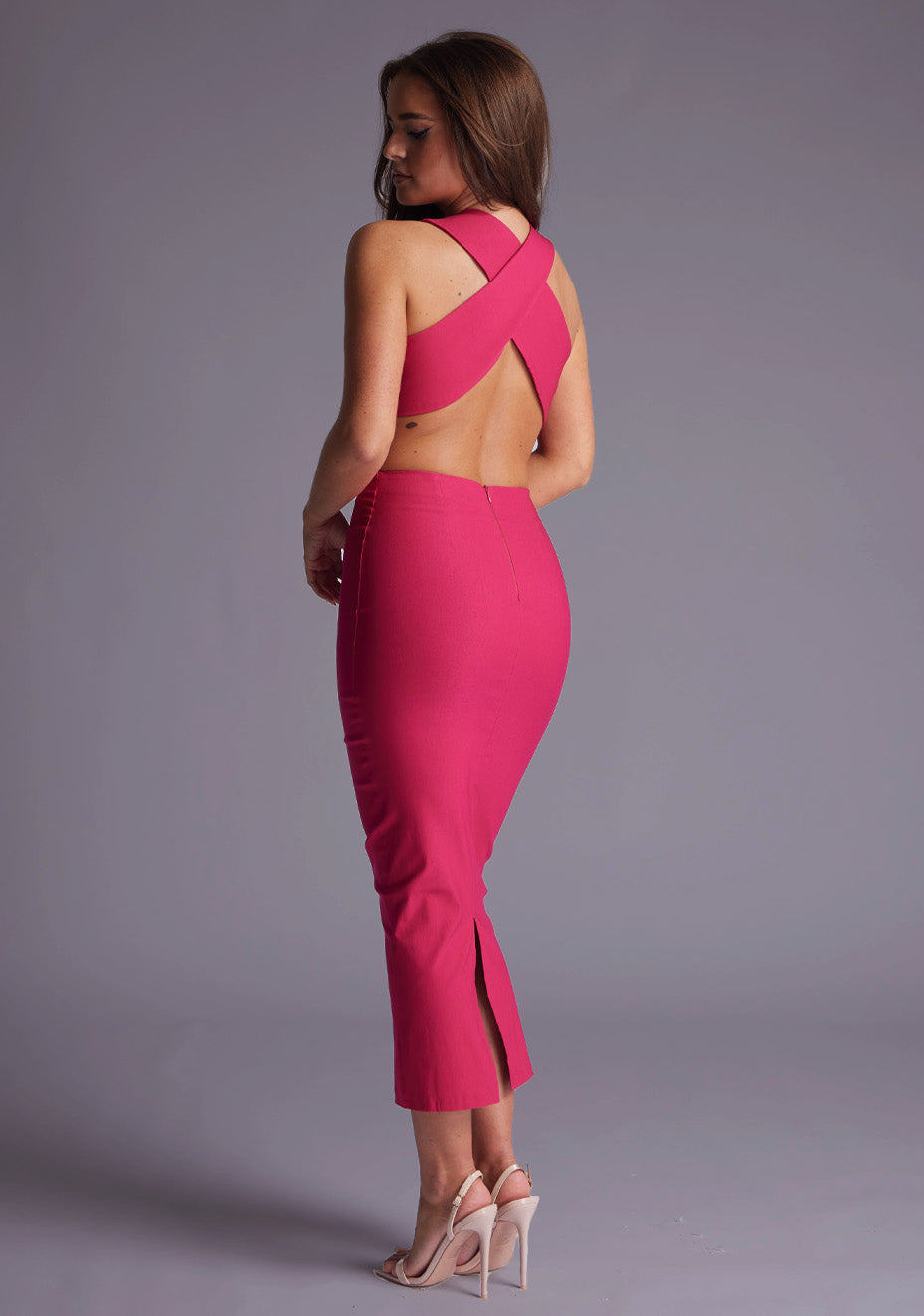Side back image of a model wearing the Vesper Cherry Plunge Midaxi Dress in Cerise, revealing the crisscross open-back detail and body-skimming fit.