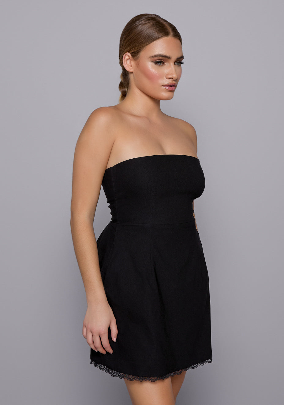 Close-up side-front view of the VSPR Emily Black Dress focusing on the sculpted bodice and strapless neckline, highlighting the soft flare and lace edge of the skirt.
