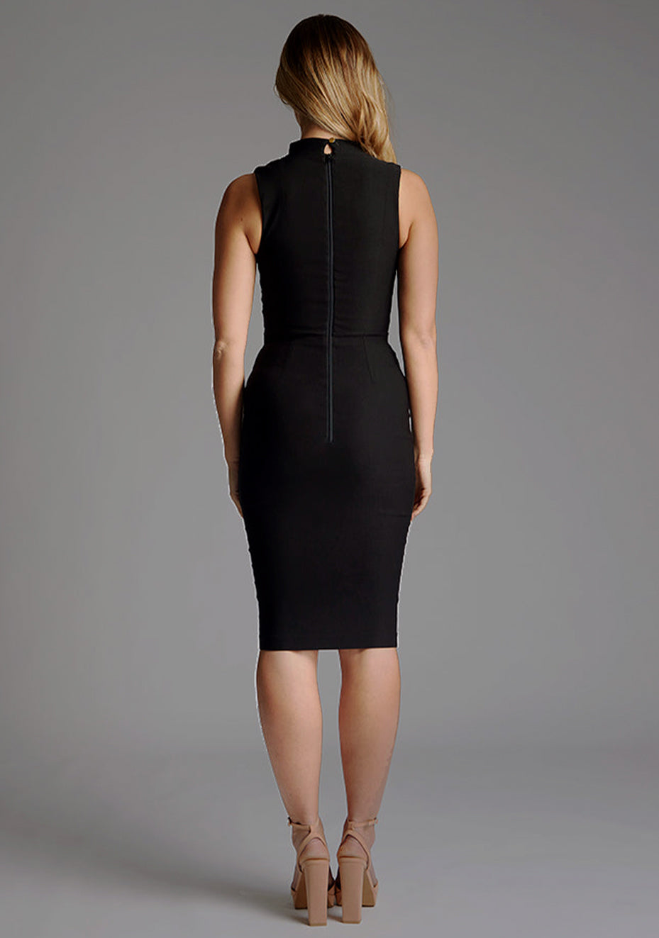 Back image of a model wearing black midi dress with a high neck and a subtle front cut-out, this dress exudes refined style. The designed featured  is the Vesper Jacqueline High Neck Midi Dress in Black.