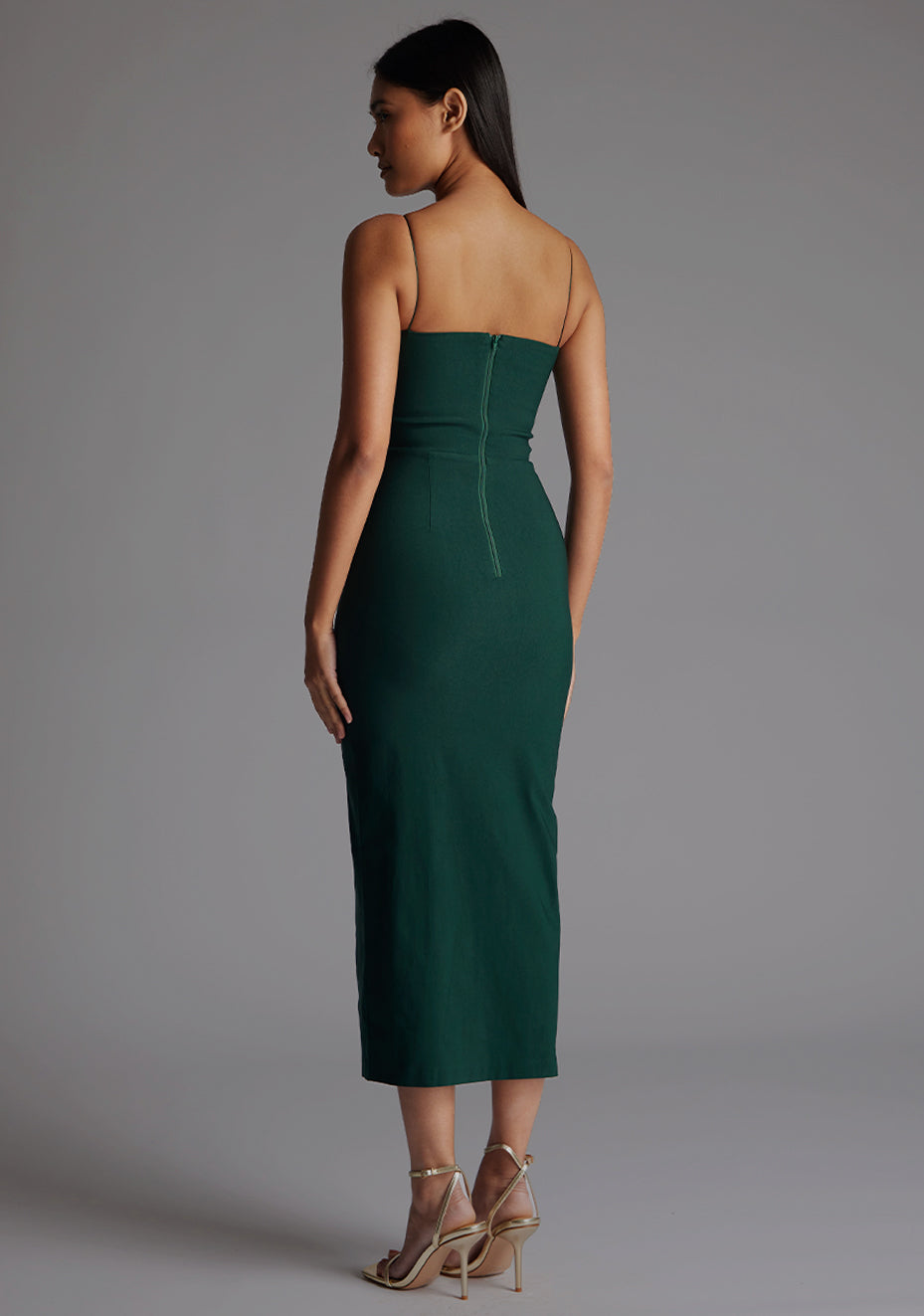 Side back image of a model wearing the  Vesper Katie Strap Detail Midaxi Dress in Forest Green, showing the streamlined fit and clean strap lines.