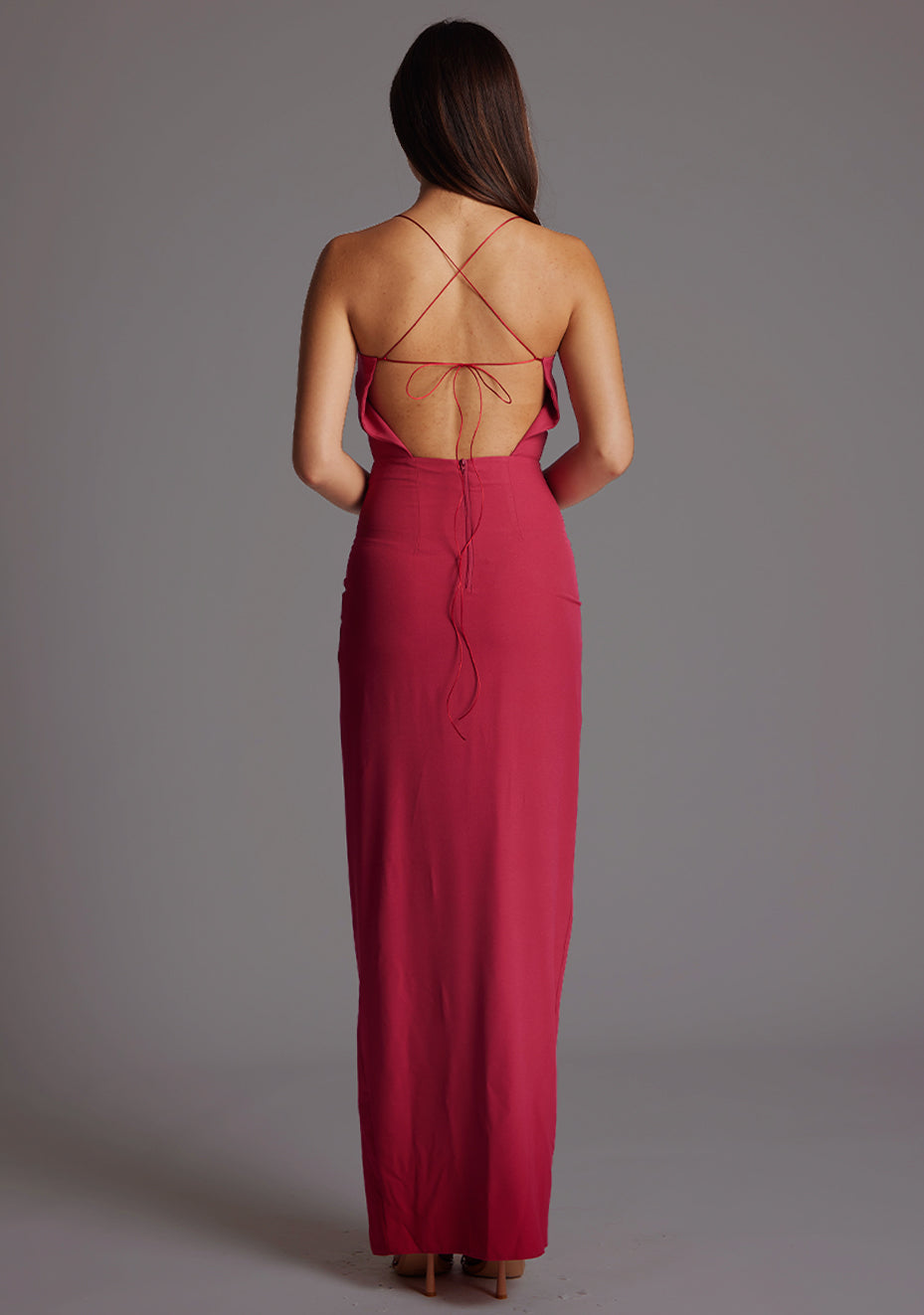 Back image of a model wearing the Vesper Maggie Sweetheart Neckline Maxi Dress in Raspberry, featuring a striking criss-cross tie back and refined, floor-length silhouette.