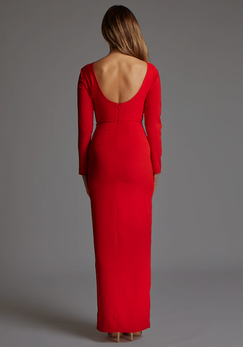 Back image of a model wearing the Vesper Mandy High Neck Long Sleeve Maxi Dress in Red, featuring a subtle scoop back and sleek floor-length finish, against a grey studio backdrop.