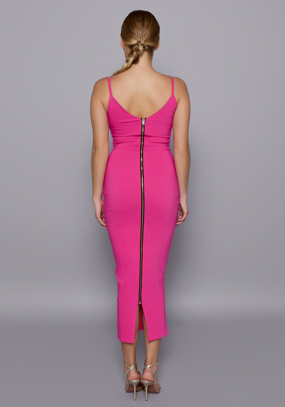 Back view of the VSPR Rea Dress in cerise featuring thin straps, a straight hemline, and a statement gold zip closure for a polished finish.