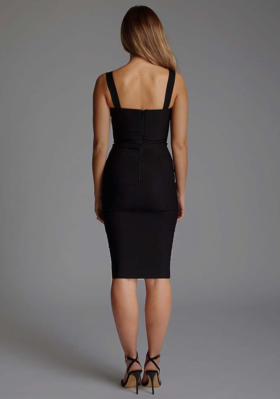 Back image of a model wearing the Vesper Solara Square Neck Ruched Bust Midi Dress in Black, featuring a smooth, minimalist finish and timeless midi-length design.
