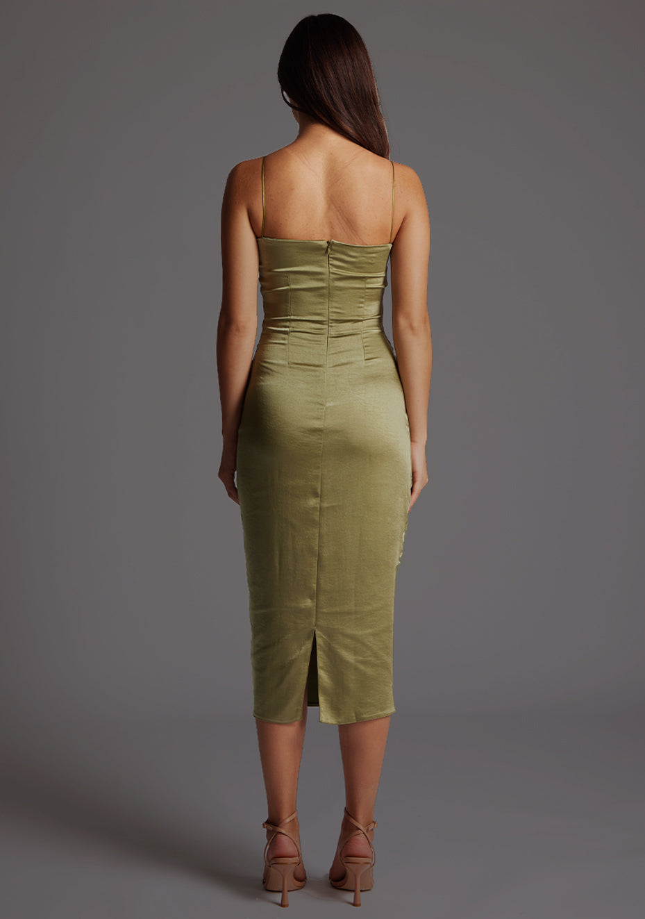 Back image of a model wearing a olive midaxi dress with a delicate thin straps, a captivating twist and front cut-out design. The design featured is the Vesper Autumn Olive Midaxi Dress