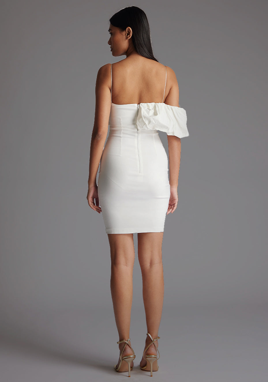 Back image of model wearing a ivory mini dress with a  delicate thin straps that enhance your shoulders and a flattering puff design. The design featured is the Vesper Hattie Ivory Mini Dress.